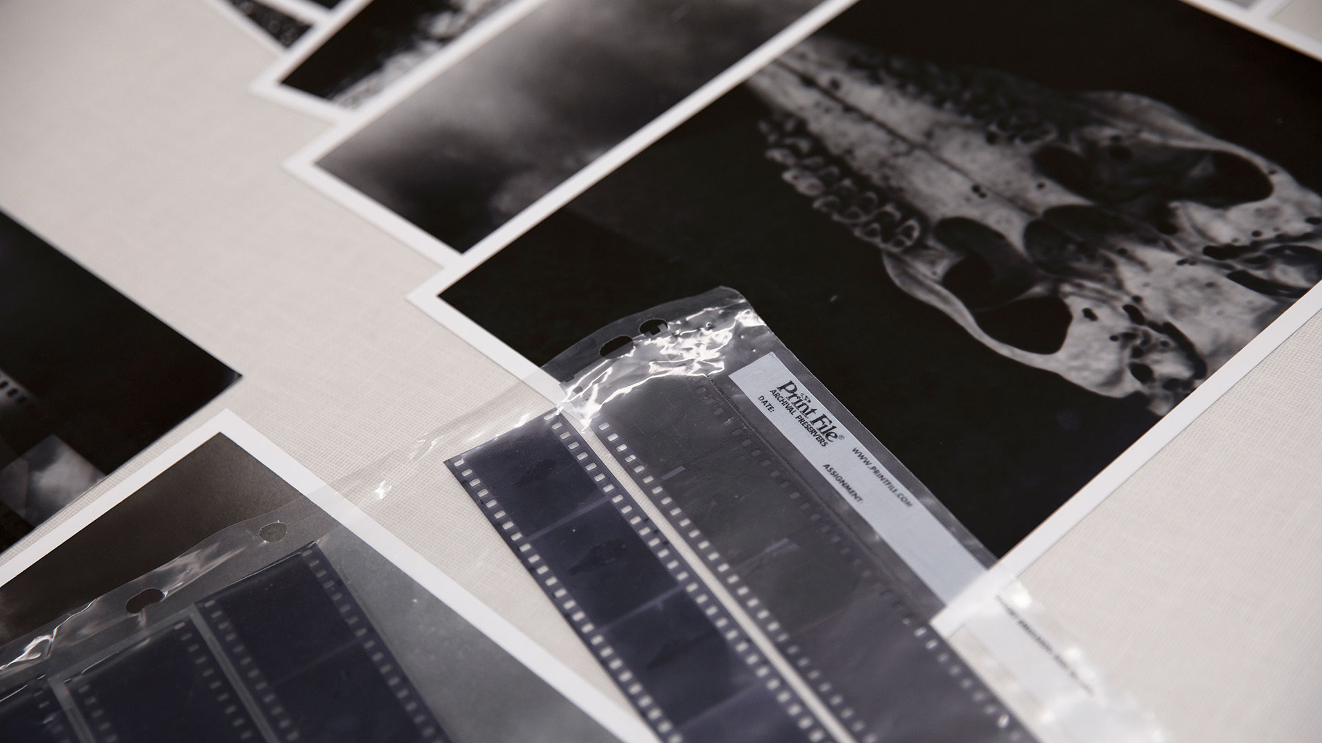 Film and photos on a table in the darkroom photography class