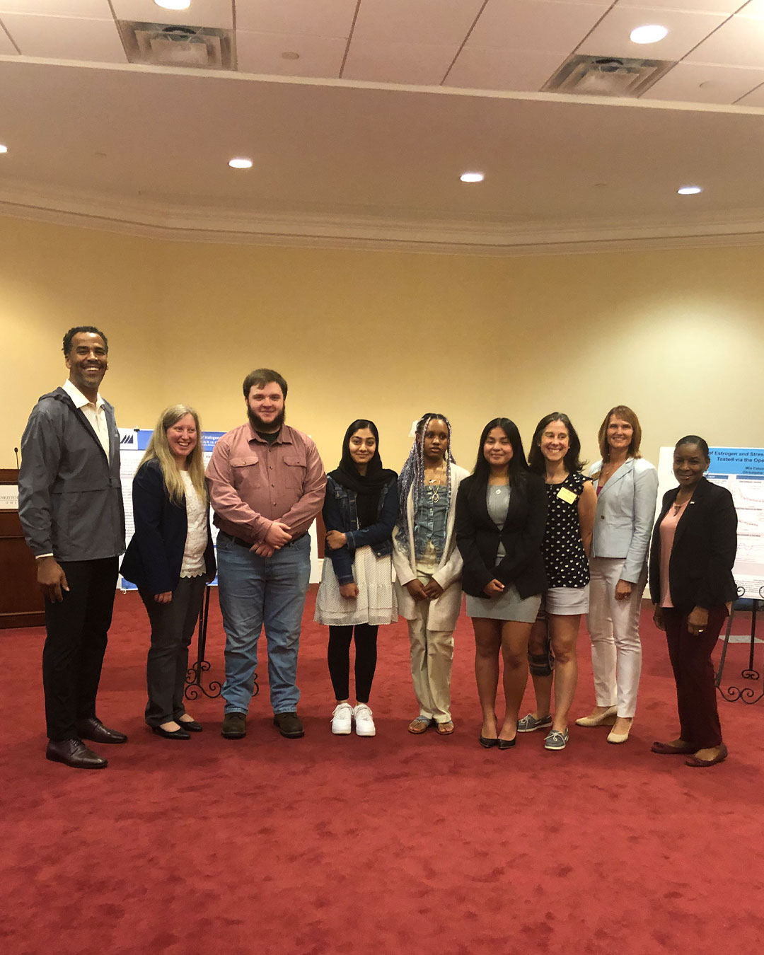 STEM Community Captains pose for a photo at a poster presentation event.