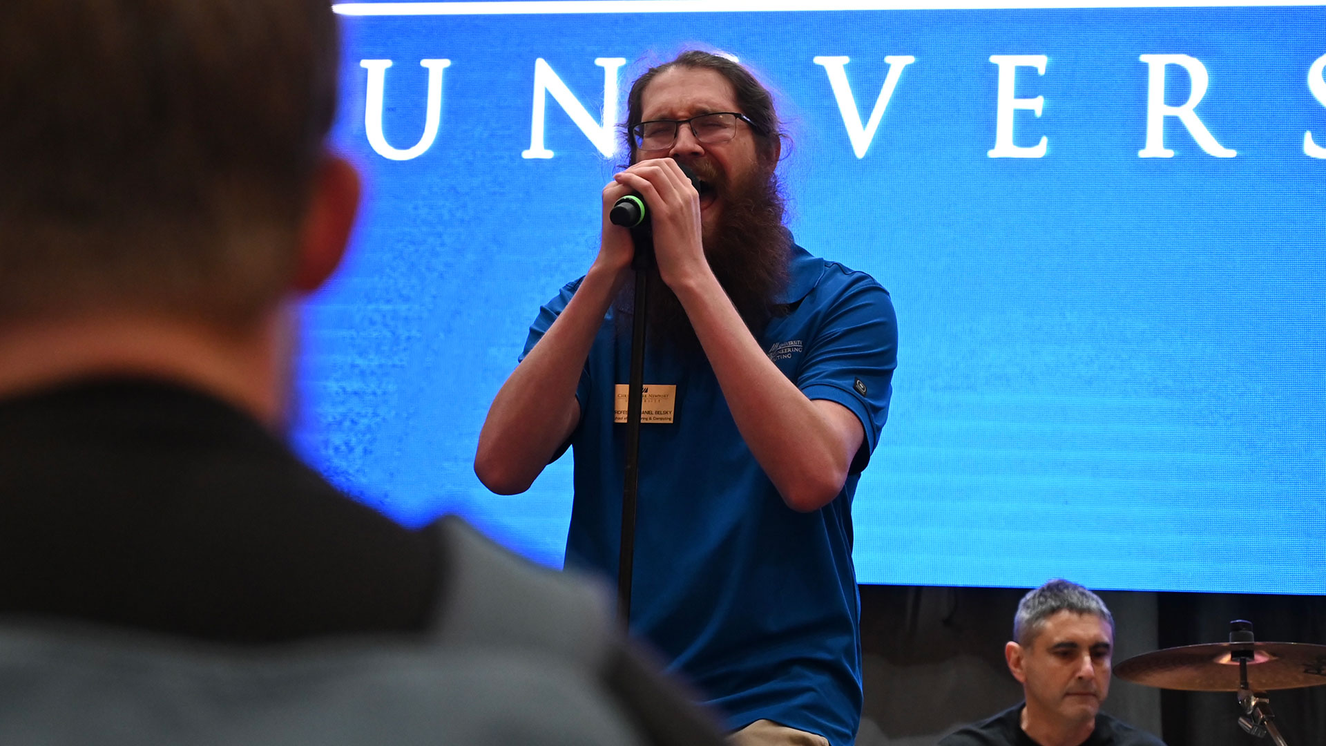A SEC professor sings into a microphone