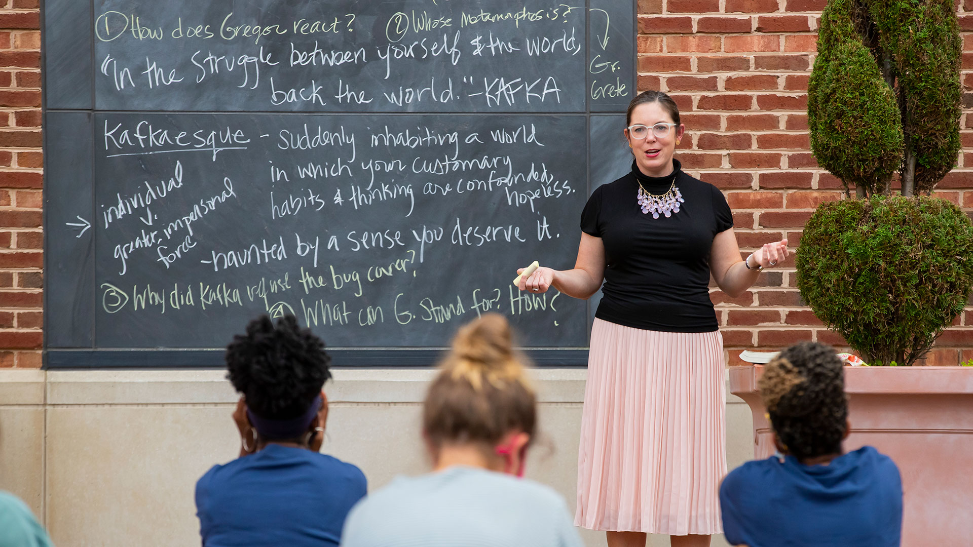 A professor teaching a class about Kafka outside