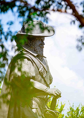 Statue of Captain Chris framed by tree branches