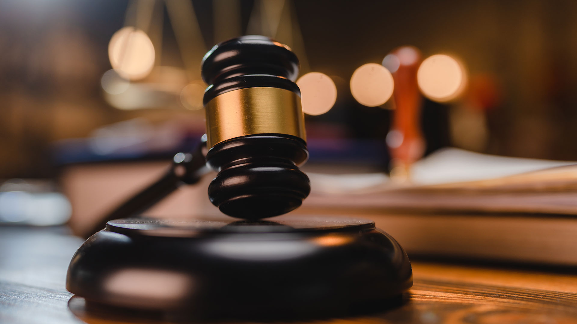 Closeup of a gavel with scales in the background